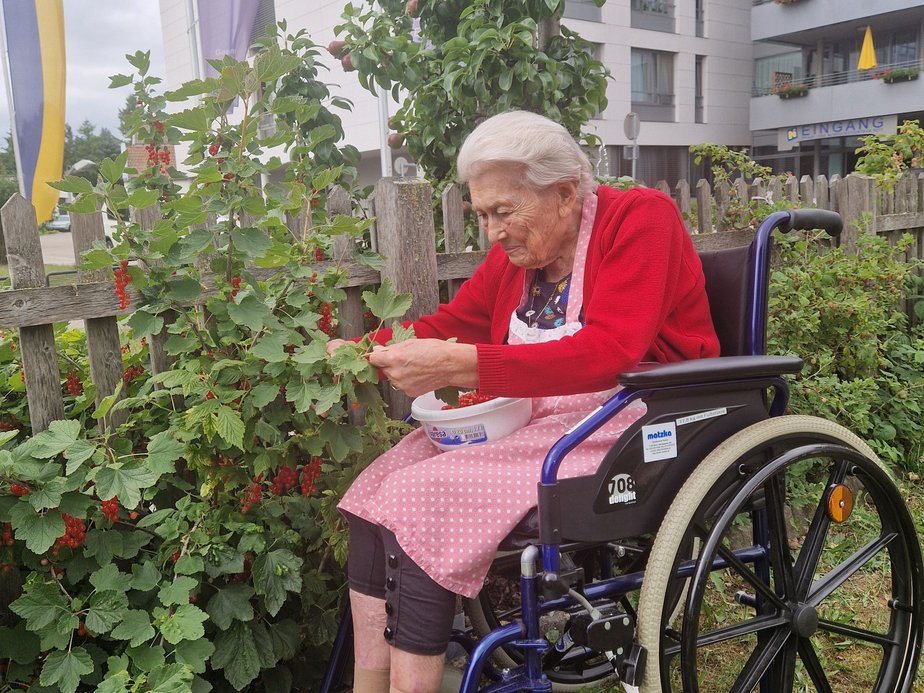 Bewohner sitzt im Garten.