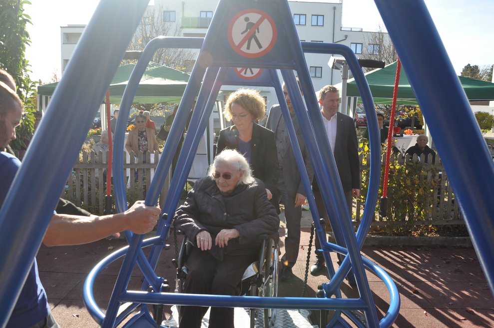Landesrätin Mag. Christiane Teschl-Hofmeister chauffiert Elfriede Bischinger auf die Rollstuhl- Schaukel